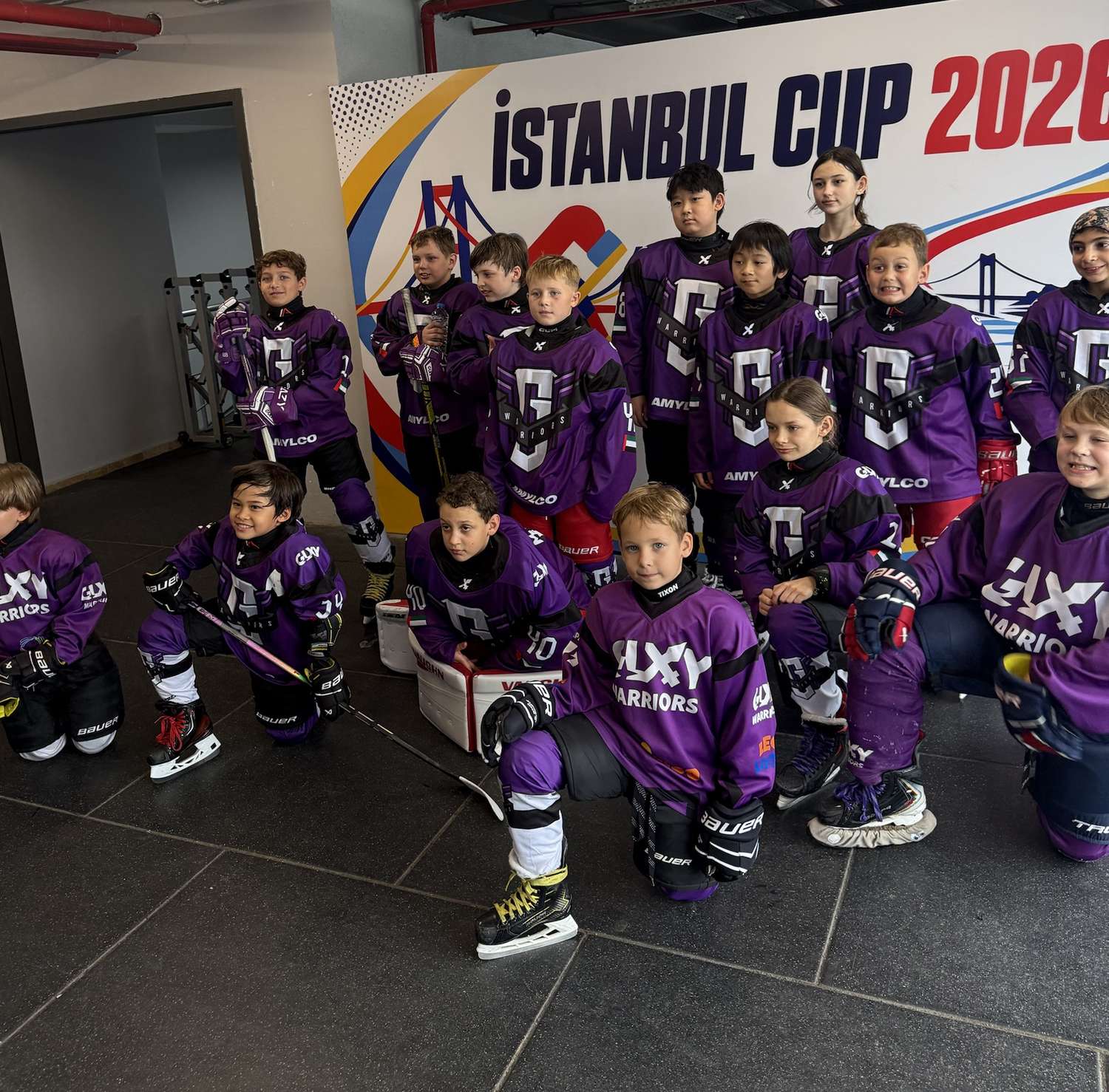 Galaxy Warriors players kneeling and standing for a team photo at the Istanbul Cup 2026 banner